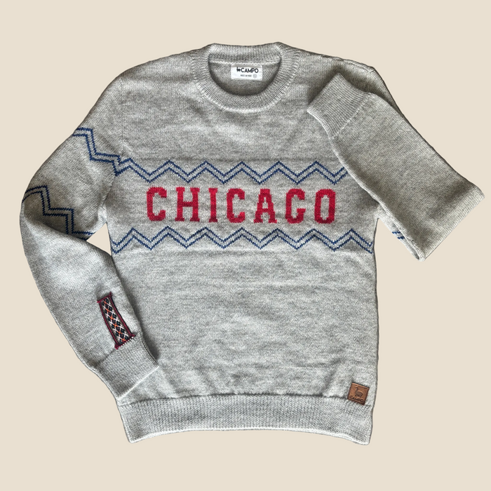 Gray sweater with 'Chicago' design on a wooden surface