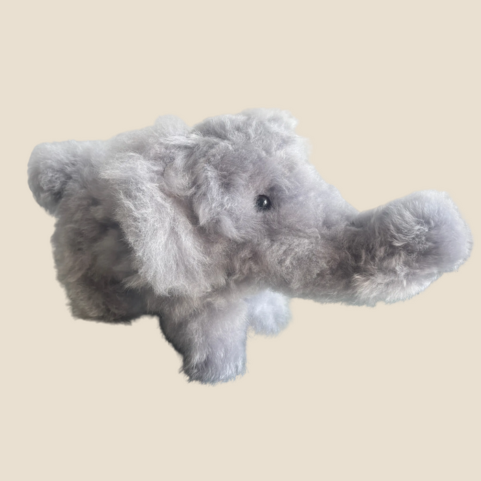 Plush elephant toy on a beige background