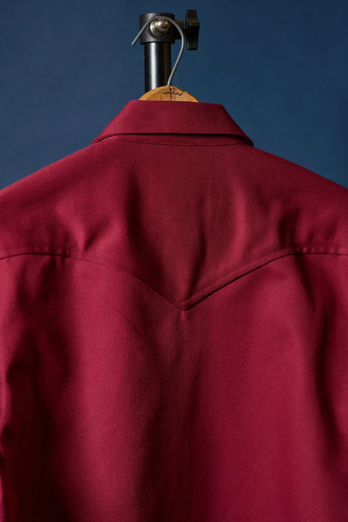 Red jacket back side on a hanger against a blue background