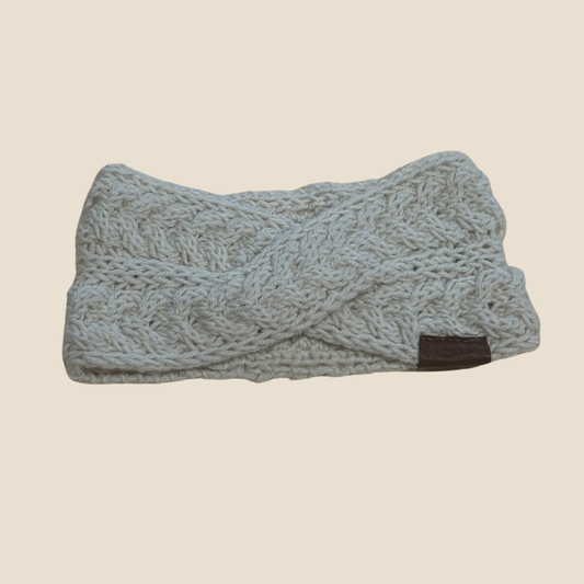 Knitted headband with braided pattern on a beige background