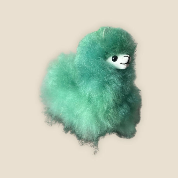 Green plush toy on a beige background
