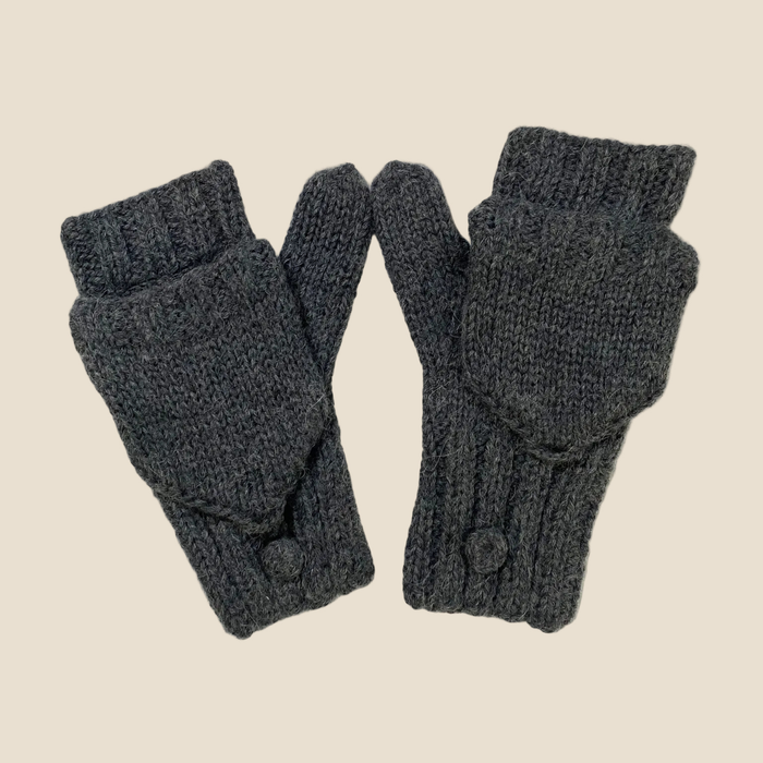 Pair of dark gray knitted fingerless gloves on a beige background