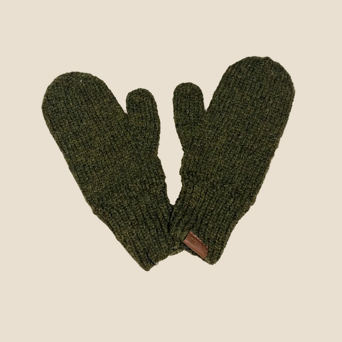 A pair of dark olive green knit mittens with a small brown leather brand tab, displayed against a solid cream background.