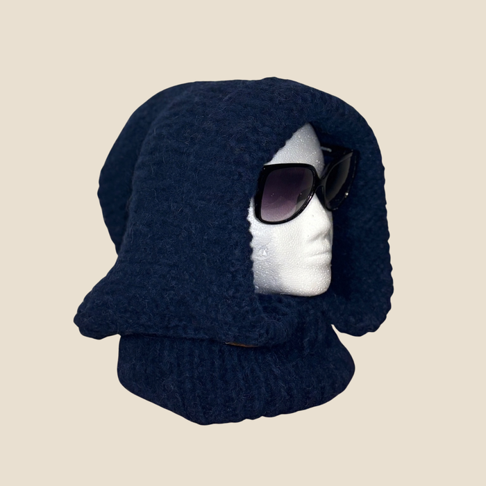 Navy blue knitted hood on a mannequin head with sunglasses on a beige background