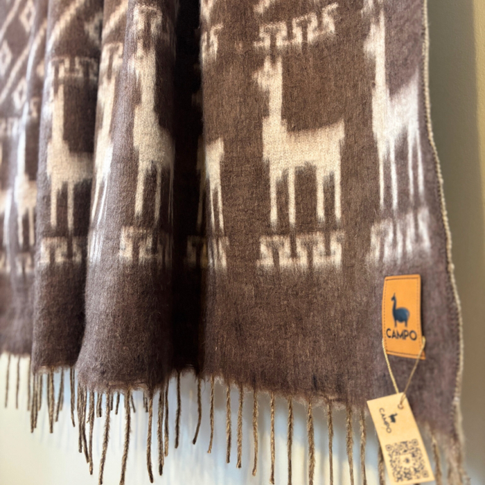 Brown scarf with alpaca pattern and 'Campo' brand tag on a blurred background