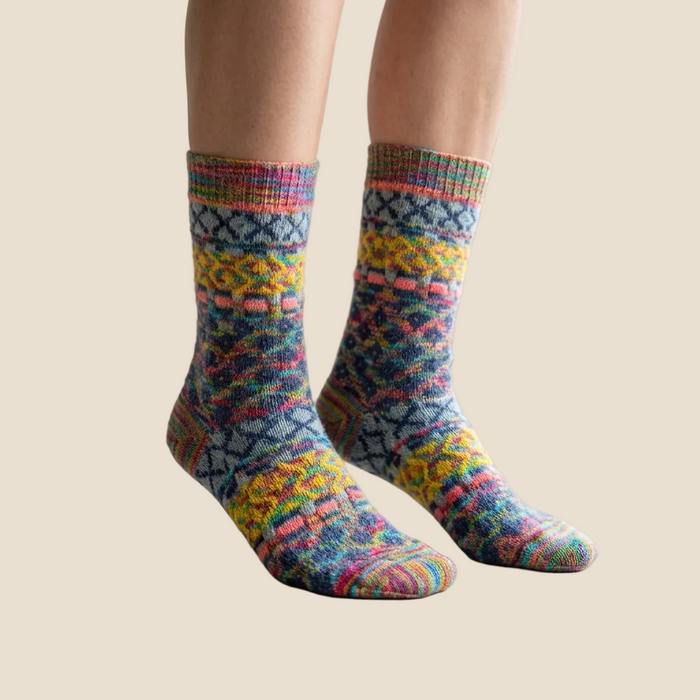 Colorful patterned socks worn by a person indoors.
