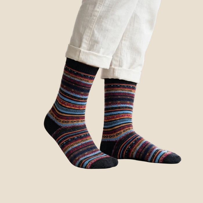 Multicolored striped socks worn with white pants on a beige background