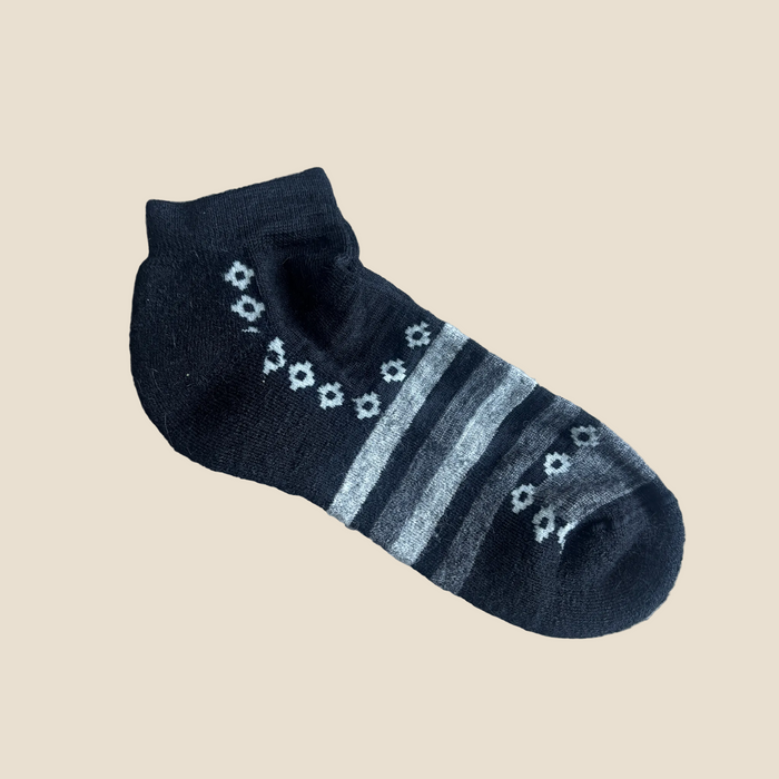 Dark blue ankle sock with light blue stripes and floral patterns on a beige background