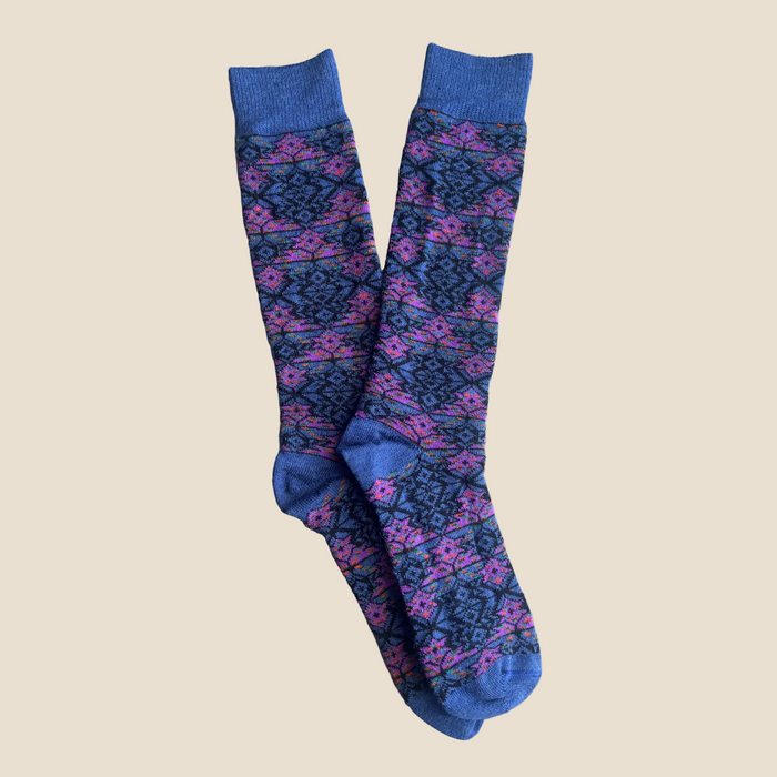 Pair of patterned socks with blue accents on a beige background