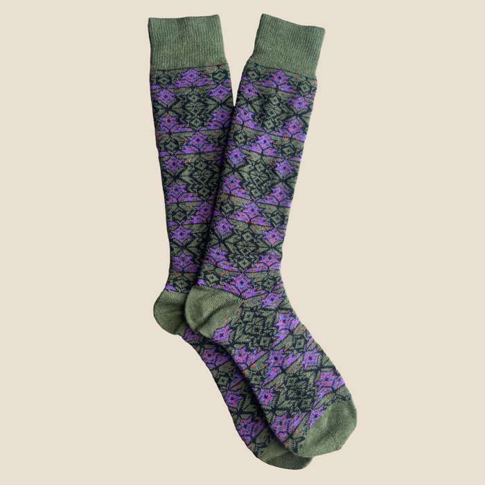 Pair of olive green knee-high socks with a purple geometric pattern on a wooden surface
