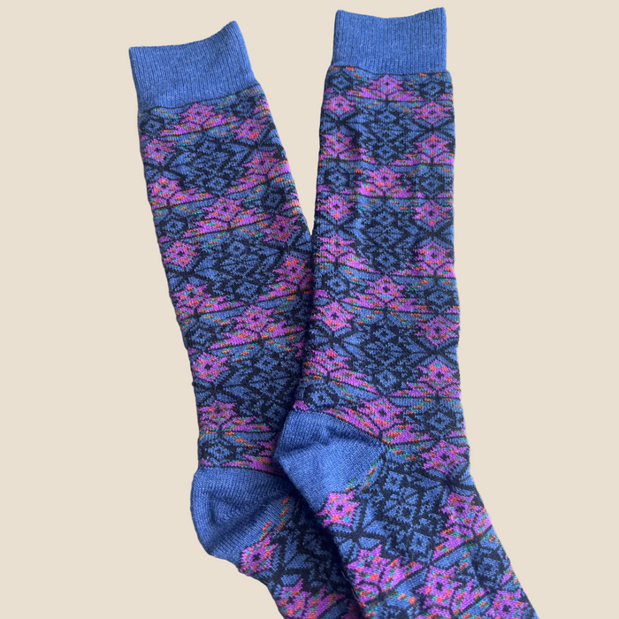 Pair of blue and purple patterned socks on a wooden surface