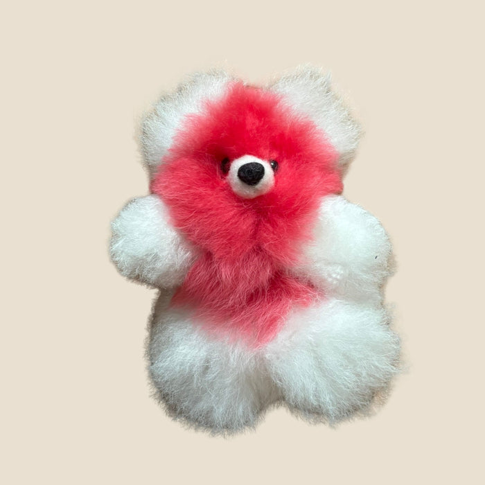 Plush toy bear with red center on a beige background
