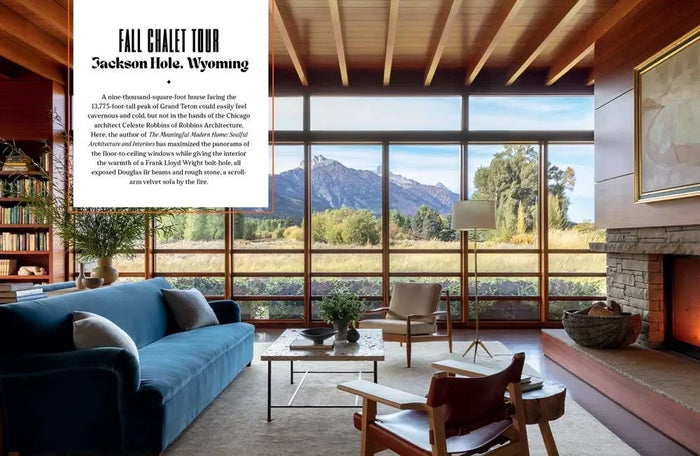 Modern chalet living room with large windows, blue sofa, fireplace, and mountain view in Jackson Hole, Wyoming