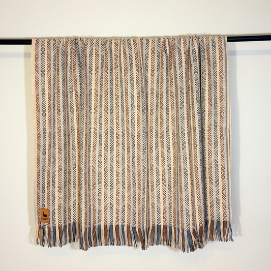 Textured blanket with a pattern draped over a surface on a white background