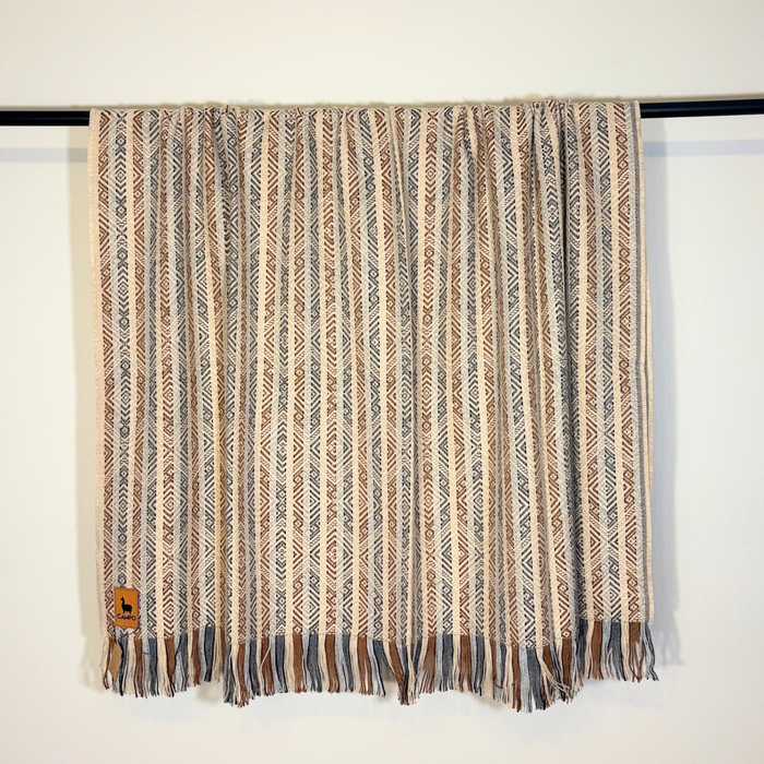 Textured blanket with a pattern draped over a surface on a white background