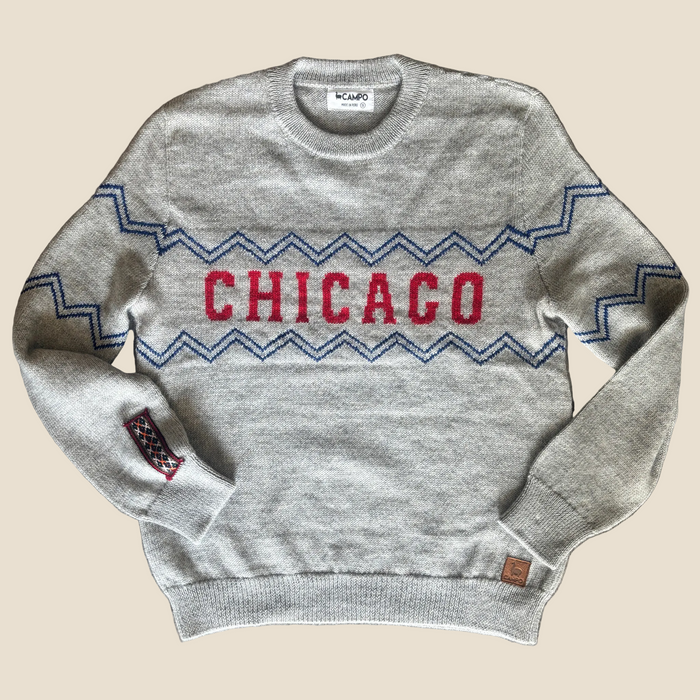 Gray sweater with 'Chicago' design on a wooden surface