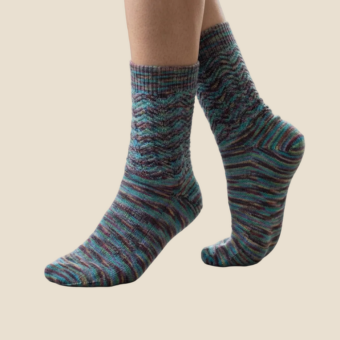 Striped socks worn by a person on a light-colored floor.