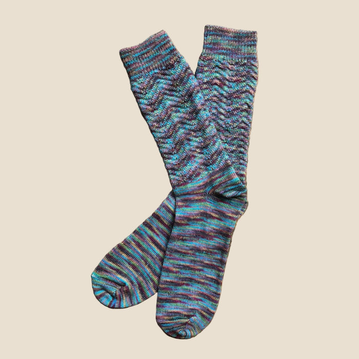 Pair of multicolored patterned socks on a beige background