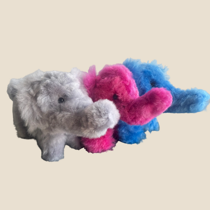Plush toy elephant with colorful tummy on a beige background