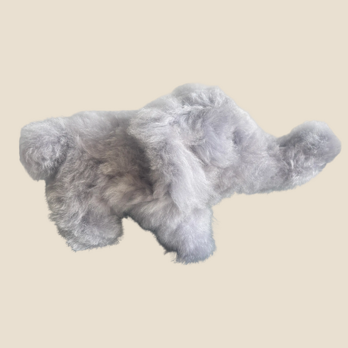 Gray plush toy elephant on a beige background