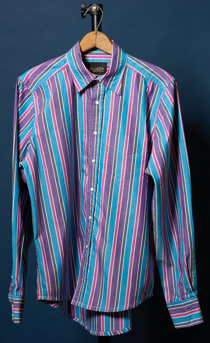 Striped shirt on a hanger against a dark background