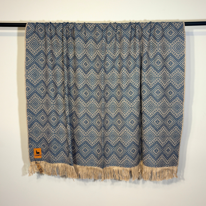 Blue patterned fabric with fringes on a white background