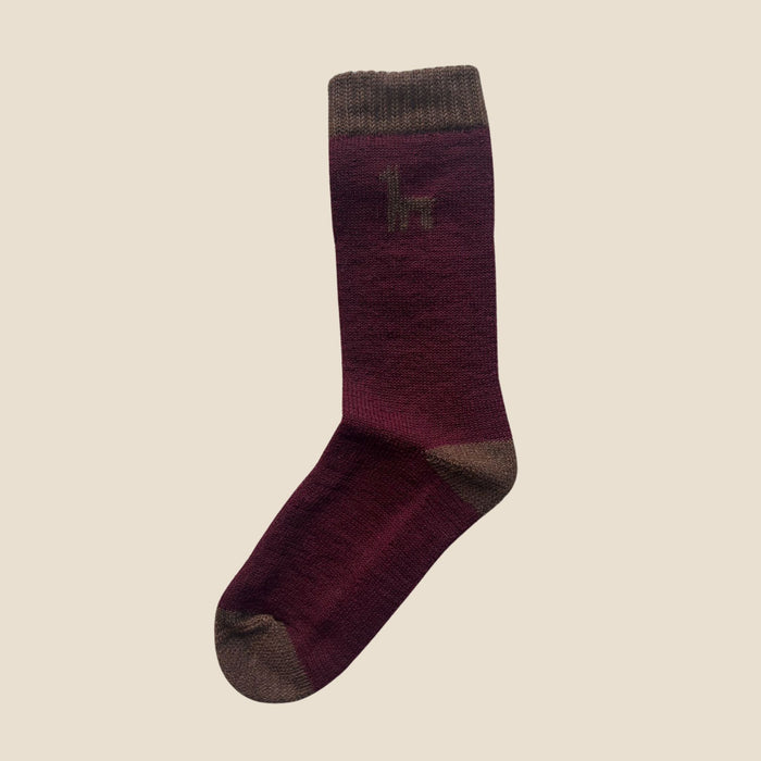 Purple sock with brown accents on a beige background