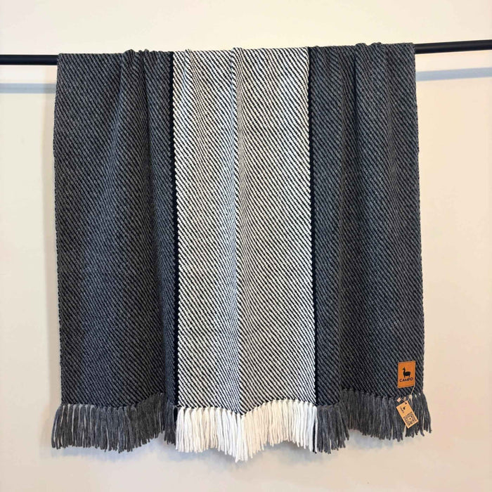 Striped scarf with fringes on a rack against a white background