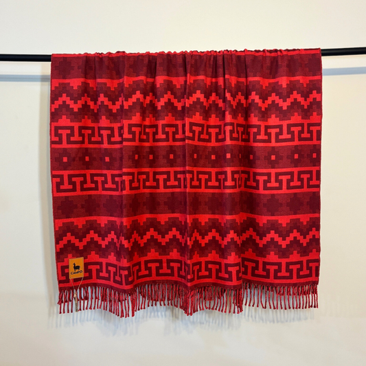 Red patterned scarf with fringes on a white background