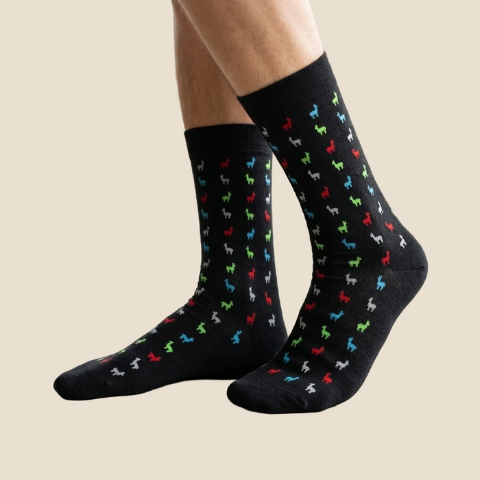 Black socks with colorful dog pattern worn indoors on a light-colored floor.