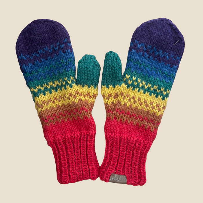 Pair of colorful knitted mittens with a rainbow pattern on a beige background