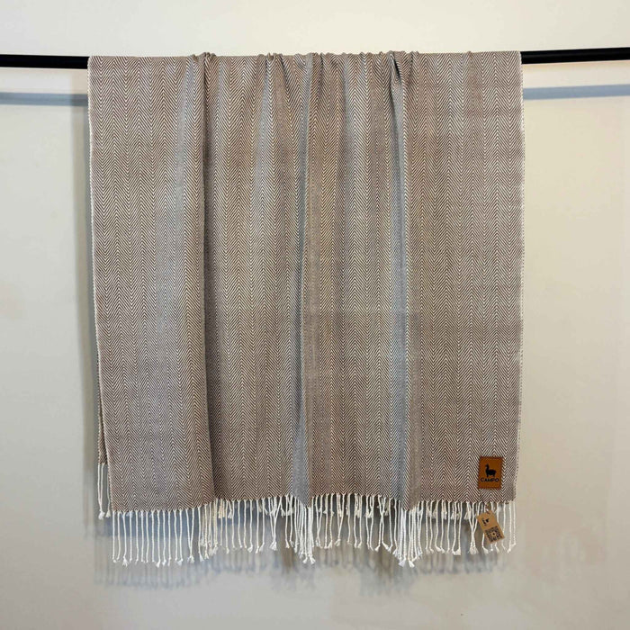 Textured throw blanket with fringes on a white background