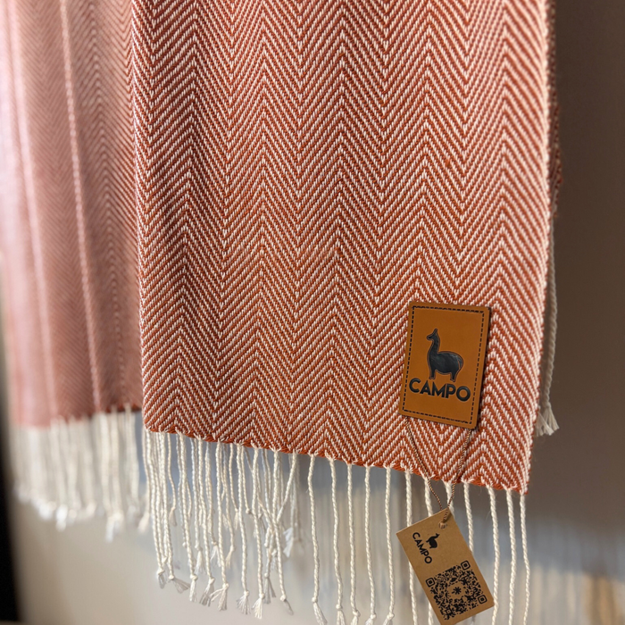 Red and white herringbone patterned blanket with 'Campo' brand tag on a neutral background