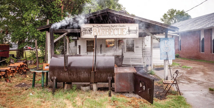Front view of barbecue smokehouse with wood smoker, smokestack, and accessibility sign