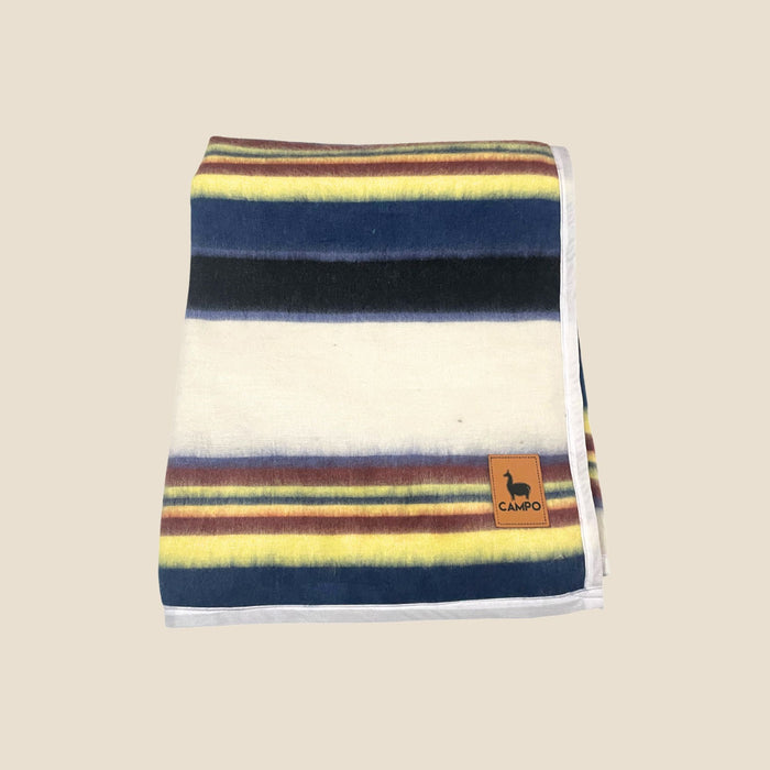 Striped blanket with a brand logo on a beige background